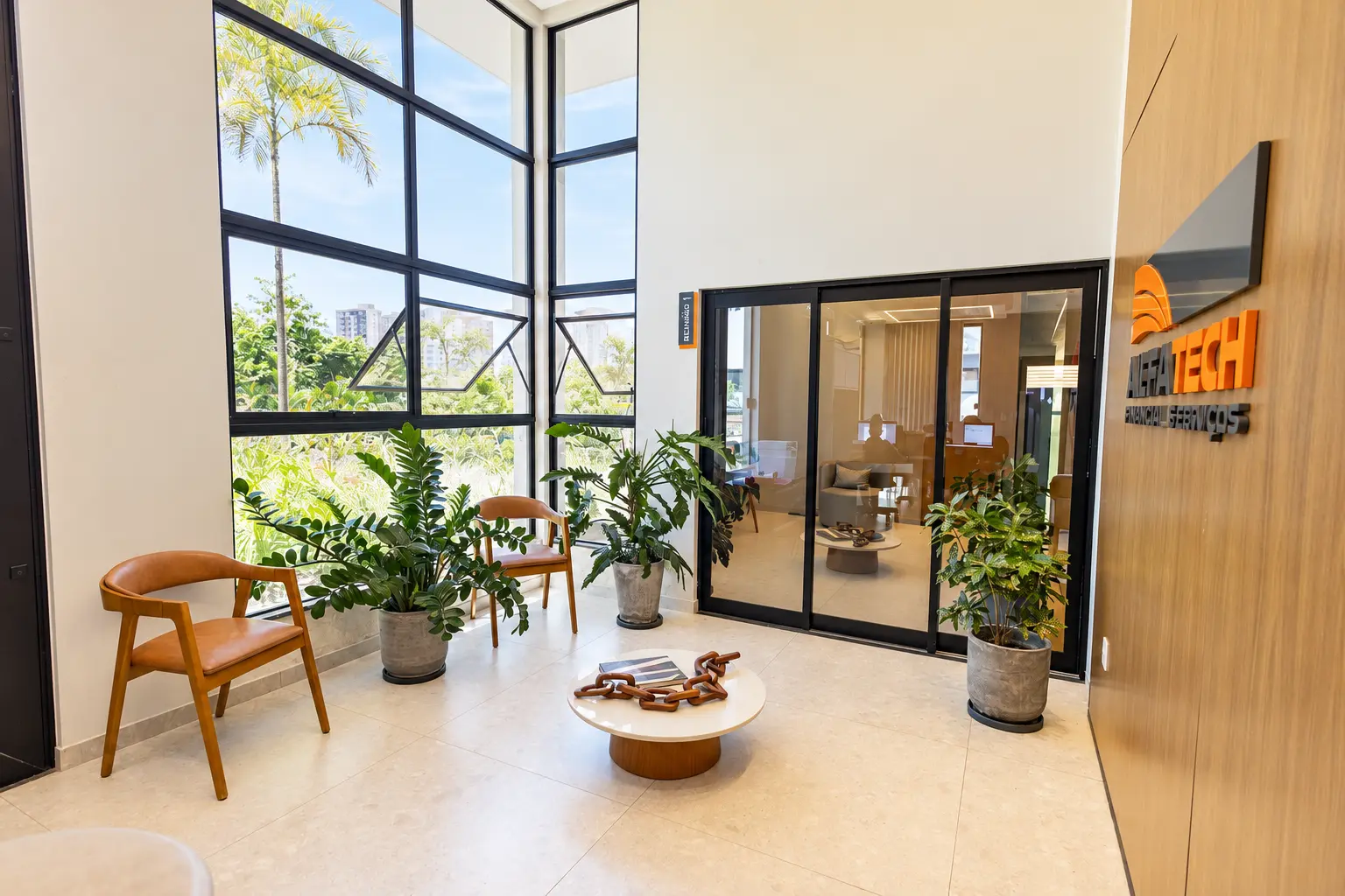 Recepção com grandes janelas e vegetação
